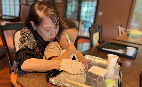 A grandparent making crafts with their grandchildren.